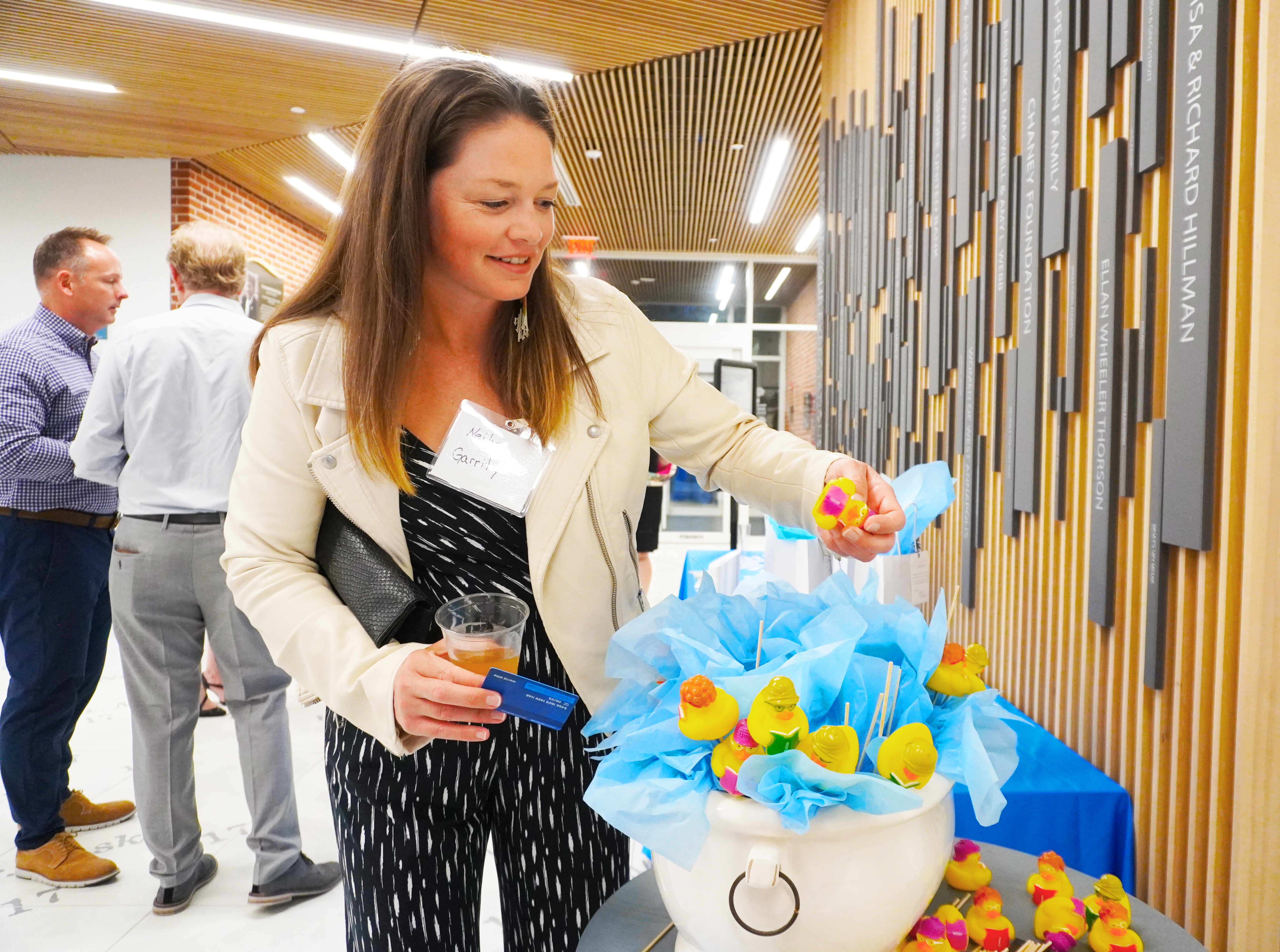 Woman playing the wine pull raffle at library event. 