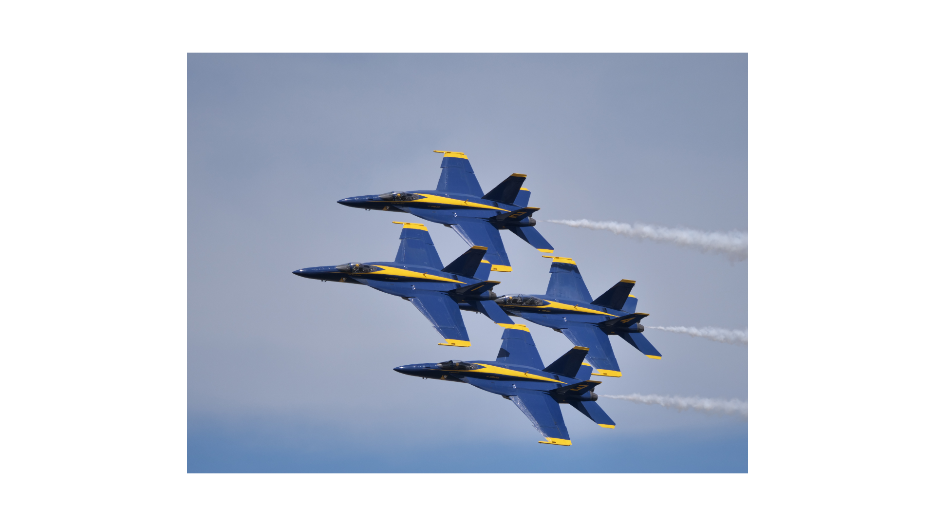 four blue and gold fighter planes flying in close formation
