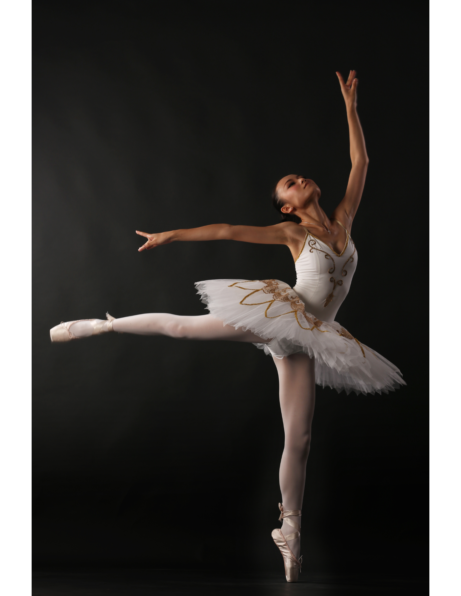 ballerina dancing in front of black background