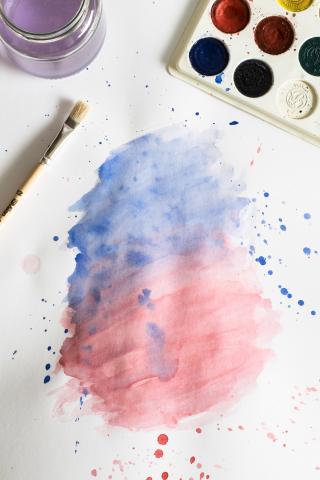 Watercolor paints and a gradient painting of blue and pink