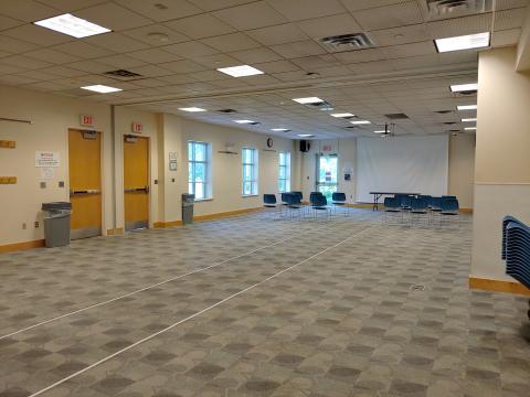 Odenton Community Meeting Room AB with half open room setup and other half of room auditorium seating with projection screen