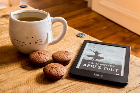 coffee cup, three cookies and an ereader