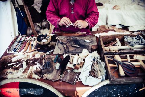 A person standing behind a display of Native American tools