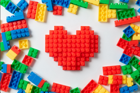 A heart built out of legos surrounded by scattered legos