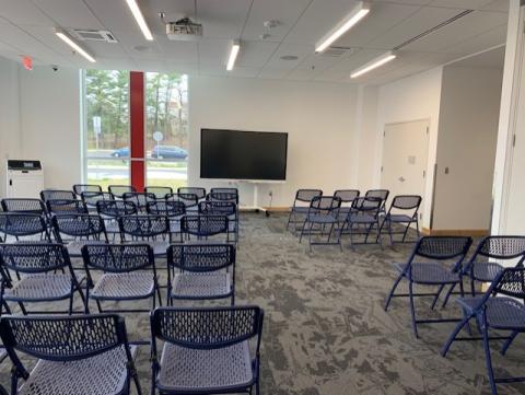 Chairs set up in front of a smartscreen in an empty meeting room